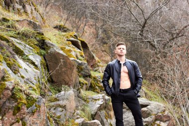 Çekici genç adam dışarıda kaslı gövde gösterisi yapıyor. Güzel vücut. Fitness ve yaşam tarzı konsepti. Basının telaffuz ettiği kaslar. Atletik fiziği.