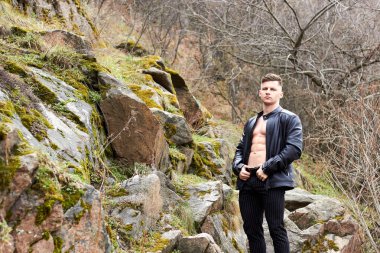 Çekici genç adam dışarıda kaslı gövde gösterisi yapıyor. Güzel vücut. Fitness ve yaşam tarzı konsepti. Basının telaffuz ettiği kaslar. Atletik fiziği.