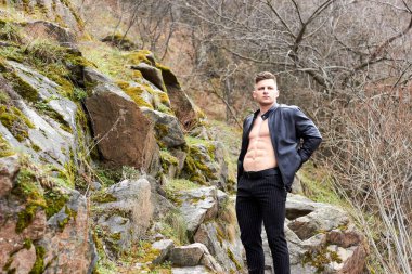 Çekici genç adam dışarıda kaslı gövde gösterisi yapıyor. Güzel vücut. Fitness ve yaşam tarzı konsepti. Basının telaffuz ettiği kaslar. Atletik fiziği.