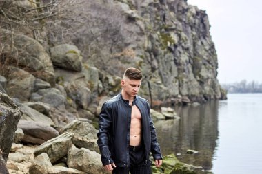 Çekici genç adam dışarıda kaslı gövde gösterisi yapıyor. Güzel vücut. Fitness ve yaşam tarzı konsepti. Basının telaffuz ettiği kaslar. Atletik fiziği.