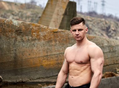 Çekici genç adam dışarıda kaslı gövde gösterisi yapıyor. Güzel vücut. Fitness ve yaşam tarzı konsepti. Basının telaffuz ettiği kaslar. Atletik fiziği.