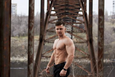 Çekici genç adam dışarıda kaslı gövde gösterisi yapıyor. Güzel vücut. Fitness ve yaşam tarzı konsepti. Basının telaffuz ettiği kaslar. Atletik fiziği.