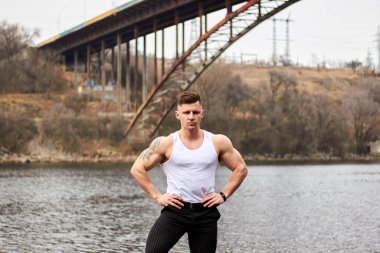 Çekici genç adam dışarıda kaslı gövde gösterisi yapıyor. Güzel vücut. Fitness ve yaşam tarzı konsepti. Basının telaffuz ettiği kaslar. Atletik fiziği.