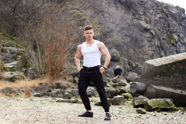 Çekici genç adam dışarıda kaslı gövde gösterisi yapıyor. Güzel vücut. Fitness ve yaşam tarzı konsepti. Basının telaffuz ettiği kaslar. Atletik fiziği.