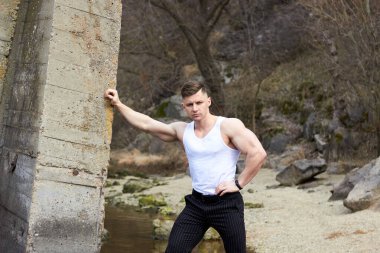 Çekici genç adam dışarıda kaslı gövde gösterisi yapıyor. Güzel vücut. Fitness ve yaşam tarzı konsepti. Basının telaffuz ettiği kaslar. Atletik fiziği.