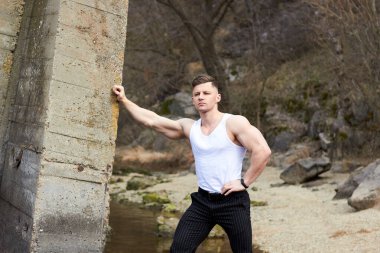 Çekici genç adam dışarıda kaslı gövde gösterisi yapıyor. Güzel vücut. Fitness ve yaşam tarzı konsepti. Basının telaffuz ettiği kaslar. Atletik fiziği.