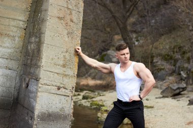 Çekici genç adam dışarıda kaslı gövde gösterisi yapıyor. Güzel vücut. Fitness ve yaşam tarzı konsepti. Basının telaffuz ettiği kaslar. Atletik fiziği.