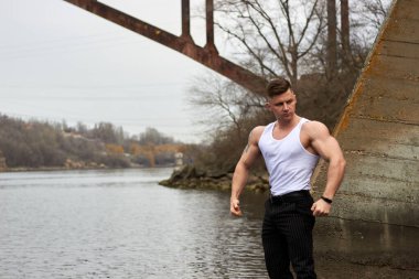 Çekici genç adam dışarıda kaslı gövde gösterisi yapıyor. Güzel vücut. Fitness ve yaşam tarzı konsepti. Basının telaffuz ettiği kaslar. Atletik fiziği.