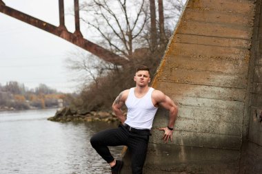 Çekici genç adam dışarıda kaslı gövde gösterisi yapıyor. Güzel vücut. Fitness ve yaşam tarzı konsepti. Basının telaffuz ettiği kaslar. Atletik fiziği.