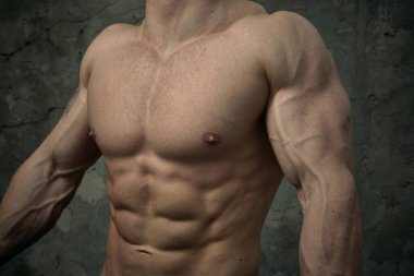 Beton duvarda poz veren yakışıklı kaslı adam. Fitness konsepti, vücut geliştirme, sağlık, yaşam tarzı. Fitness fitness modelinin portresi.