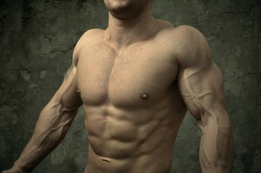 Beton duvarda poz veren yakışıklı kaslı adam. Fitness konsepti, vücut geliştirme, sağlık, yaşam tarzı. Fitness fitness modelinin portresi.