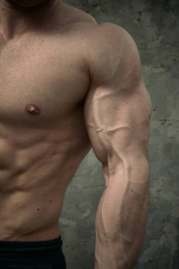 Beton duvarda poz veren yakışıklı kaslı adam. Fitness konsepti, vücut geliştirme, sağlık, yaşam tarzı. Fitness fitness modelinin portresi.