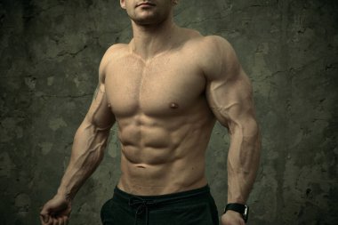 Beton duvarda poz veren yakışıklı kaslı adam. Fitness konsepti, vücut geliştirme, sağlık, yaşam tarzı. Fitness fitness modelinin portresi.