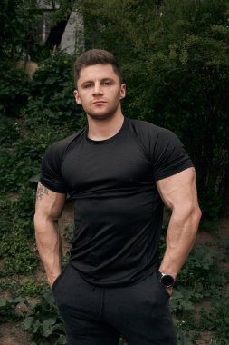 Spor tişörtlü bir adamın çekici atletik portresi. Bir fitness modelinin güzel portresi. Fitness, sağlık, yaşam tarzı kavramı. Spor kıyafetleri..