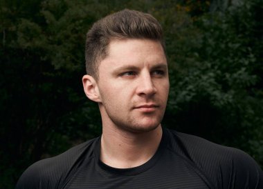 Spor tişörtlü bir adamın çekici atletik portresi. Bir fitness modelinin güzel portresi. Fitness, sağlık, yaşam tarzı kavramı. Spor kıyafetleri..