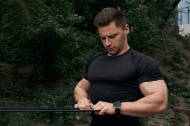 Atletik çekici adam dışarıda antrenman yapıyor. Spor, sağlık, fitness konsepti. Spor tişörtlü genç adam..