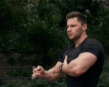 Atletik çekici adam dışarıda antrenman yapıyor. Spor, sağlık, fitness konsepti. Spor tişörtlü genç adam..