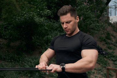 Atletik çekici adam dışarıda antrenman yapıyor. Spor, sağlık, fitness konsepti. Spor tişörtlü genç adam..