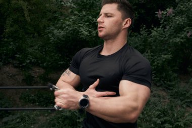 Atletik çekici adam dışarıda antrenman yapıyor. Spor, sağlık, fitness konsepti. Spor tişörtlü genç adam..