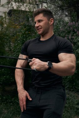 Atletik çekici adam dışarıda antrenman yapıyor. Spor, sağlık, fitness konsepti. Spor tişörtlü genç adam..