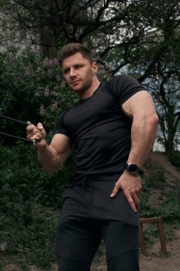 Atletik çekici adam dışarıda antrenman yapıyor. Spor, sağlık, fitness konsepti. Spor tişörtlü genç adam..