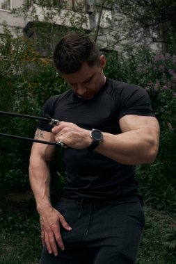 Atletik çekici adam dışarıda antrenman yapıyor. Spor, sağlık, fitness konsepti. Spor tişörtlü genç adam..