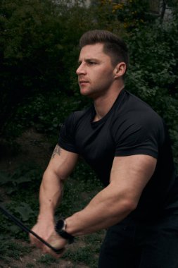 Atletik çekici adam dışarıda antrenman yapıyor. Spor, sağlık, fitness konsepti. Spor tişörtlü genç adam..