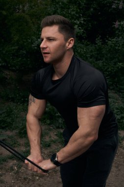 Atletik çekici adam dışarıda antrenman yapıyor. Spor, sağlık, fitness konsepti. Spor tişörtlü genç adam..