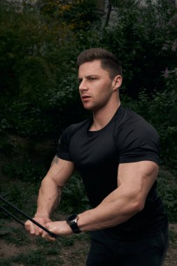 Atletik çekici adam dışarıda antrenman yapıyor. Spor, sağlık, fitness konsepti. Spor tişörtlü genç adam..