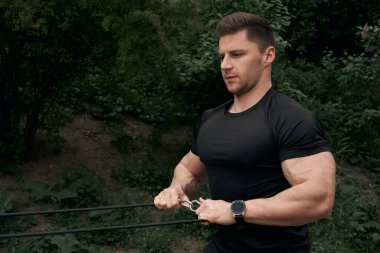 Atletik çekici adam dışarıda antrenman yapıyor. Spor, sağlık, fitness konsepti. Spor tişörtlü genç adam..