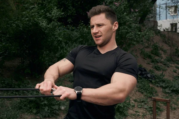 Atletik çekici adam dışarıda antrenman yapıyor. Spor, sağlık, fitness konsepti. Spor tişörtlü genç adam..