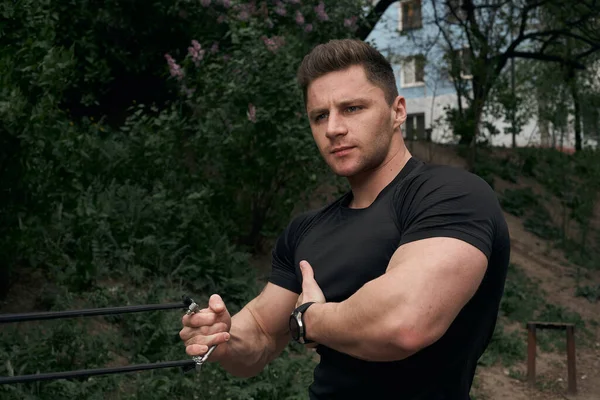 Atletik çekici adam dışarıda antrenman yapıyor. Spor, sağlık, fitness konsepti. Spor tişörtlü genç adam..