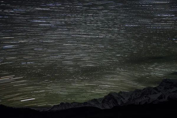 Montañas estrellas pistas nubes cielo — Foto de Stock