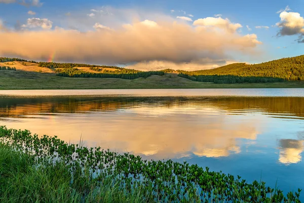 Bergen sjön regnbåge moln sommar Stockfoto