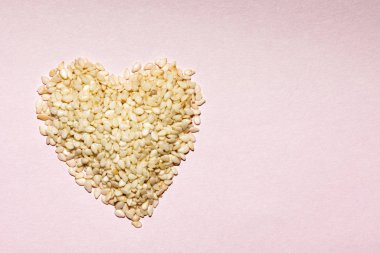 heart made of sesame seeds on pink, valentines day and health concept
