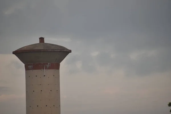 Réservoir aérien en béton cimenté qui fournit de l'eau aux populations rurales vivantes. avec le fond du ciel — Photo