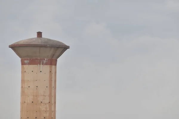 Una vista superior del tanque de almacenamiento de agua de hormigón de cemento, que suministra agua a la población rural viva. con el fondo del cielo —  Fotos de Stock