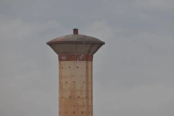 Una vista superior del tanque de almacenamiento de agua de hormigón de cemento, que suministra agua a la población rural viva. con el fondo del cielo —  Fotos de Stock