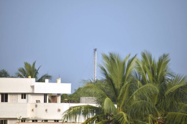 Kasabadaki inşaat ve ağaçlarla birlikte fabrikadan gelen gazlı boru manzarası..