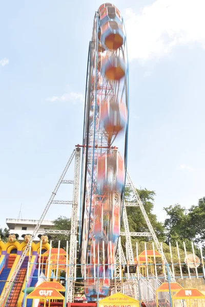 Hindistan 'da mavi gökyüzünün arka planında hareket bulanıklığı olan dev bir tekerlek ya da dönme dolap..