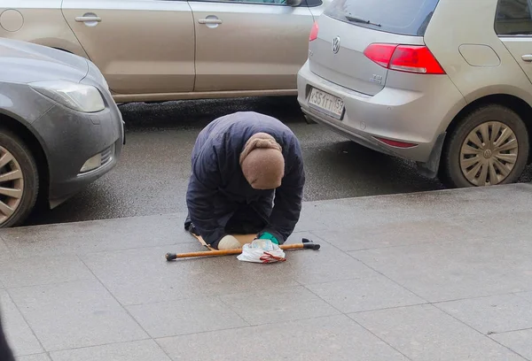 Yaşlı bir dilenci kadın yemek için para istiyor.