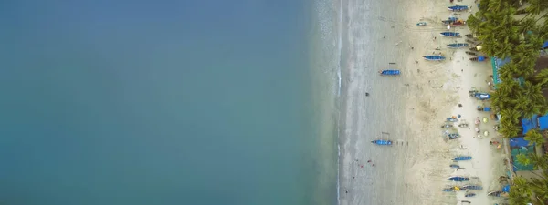 Вид с воздуха на красивое побережье Индийского океана с тропическим лесом, песчаный пляж, спокойная голубая вода и рыбацкие лодки в Гоа — стоковое фото