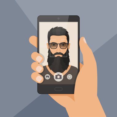 Hipster sakallı adam oduncu bir smartphone kullanarak selfie alır.