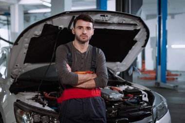 Modern bir otomobil hizmet merkezinde, kameranın önünde üniformalı bir tamirci.