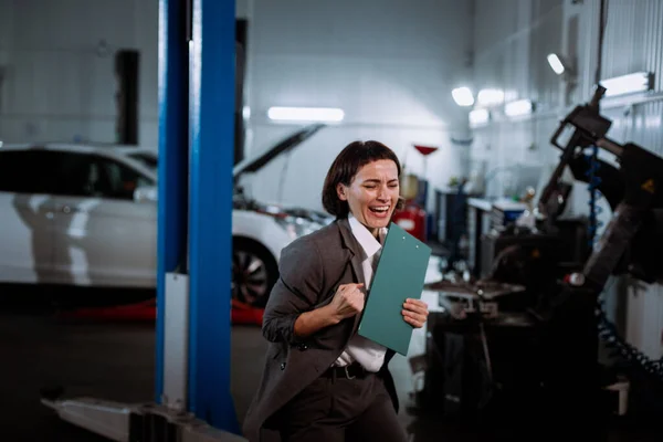 Stylish manager woman in a suit in a service auto enjoy excited in front of the camera