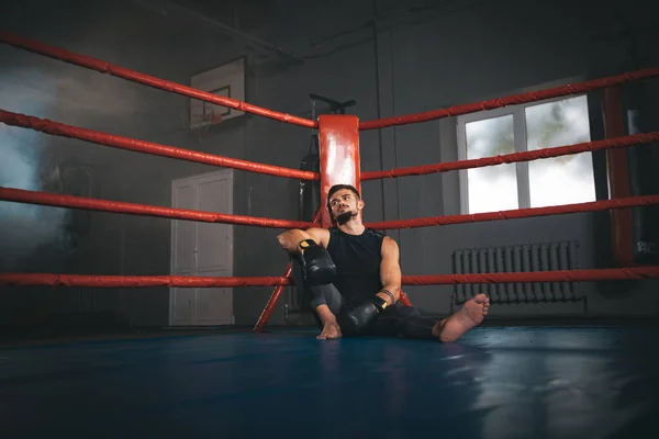 In einem dunklen Boxring haben attraktive, gut sitzende Kerle nach intensivem Training eine Pause — Stockfoto