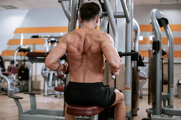 Modern bir spor salonunda kaslı adam onun triceps için egzersizler yapıyor çok çalışma konsantre