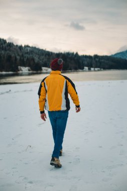 Genç Turizm adama hayranım muhteşem görünümü göl ve dağ karlı ormanı ile kışın ortasında, o mutlu peyzaj
