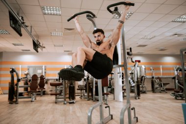Modern bir spor salonunda kaslı adam onun triceps için egzersizler yapıyor çok çalışma konsantre