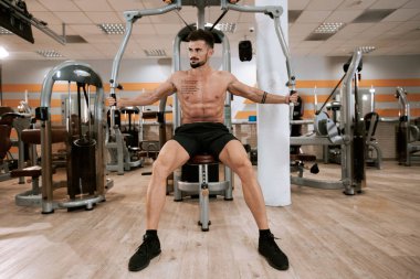 Spor salonunda spor yapmaya odaklanan kaslı sporcu vücut geliştirici spor modeli.